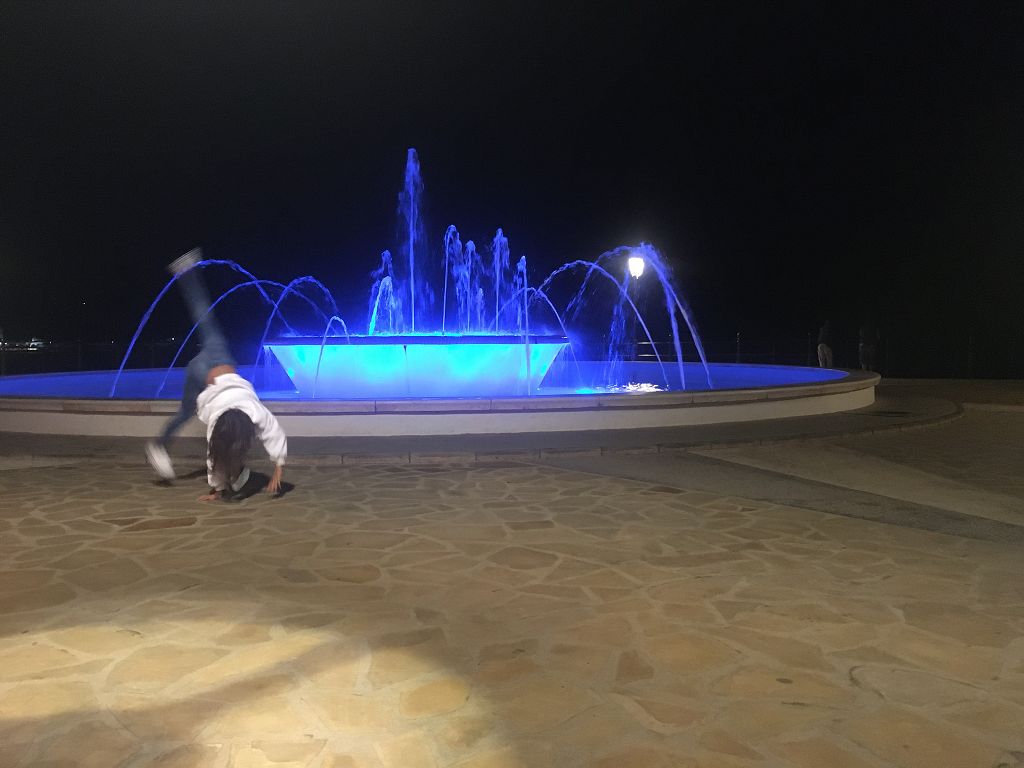 Radschläger am beleuchteten Brunnen